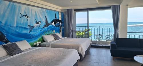 a bedroom with two beds and a view of the ocean at Love in the Gulf in Checheng