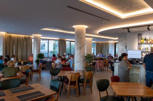 a restaurant with people sitting at tables and a bar at Hotel Dior in Krujë