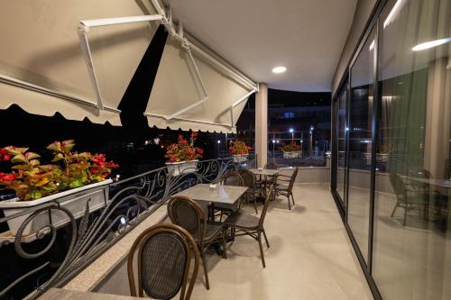 a restaurant with tables and chairs on a balcony at Hotel Dior in Krujë