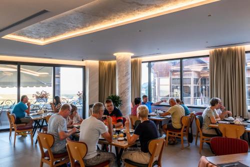 a group of people sitting at tables in a restaurant at Hotel Dior in Krujë