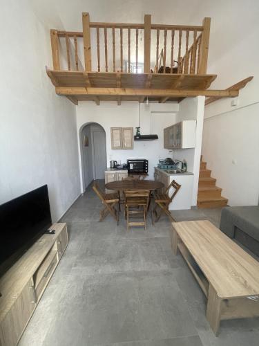 a living room with a wooden table and a kitchen at Aliki's Apartments in Vóthon