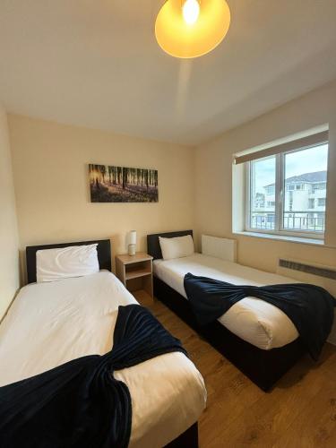 two beds in a room with a window at Four Bedroom Apartment Athlone in Creggan