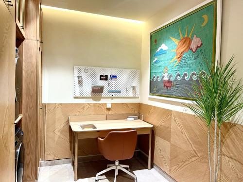 an office with a desk and a chair and a painting at AARU Maadi Luxe Retreat in Cairo