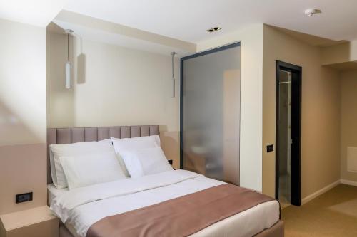 a bedroom with a large bed with white pillows at Adler Hotel in Prizren