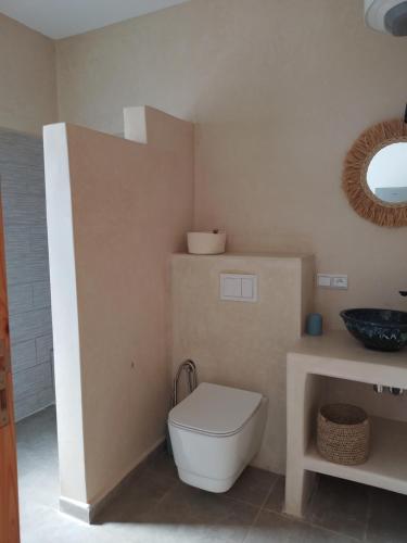 a bathroom with a toilet and a sink at Charmante maison indépendante in Oulad el Madani