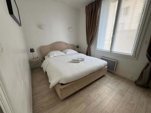 une chambre avec un grand lit avec une grande fenêtre dans l'établissement C090 Appartement confortable proche du Suquet et du Palais des festivals, à Cannes