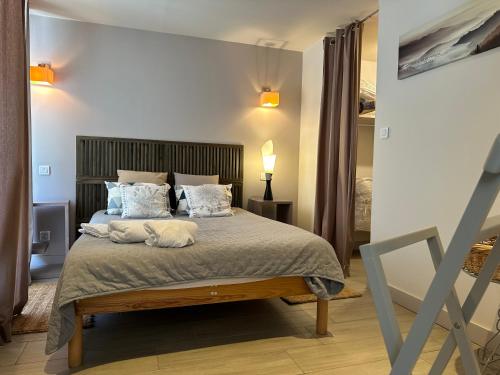 une chambre avec un grand lit avec des oreillers dans l'établissement Bambou lodge anduze, les pieds dans l'eau, à Anduze