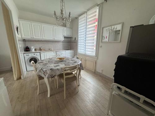 une cuisine avec une table et une cuisine avec un lustre dans l'établissement C090 Appartement confortable proche du Suquet et du Palais des festivals, à Cannes