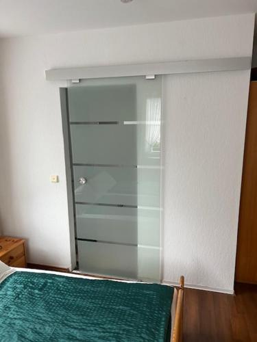 a bedroom with a green bed and a glass closet at Gästehaus Elisabeth Bach in Mehring