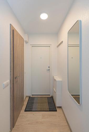 a hallway with a white door and a mirror at Pramonės Apartment #11 by PoloApartments in Kaunas