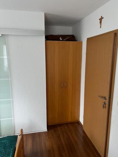 an empty room with a door and a wooden closet at Gästehaus Elisabeth Bach in Mehring