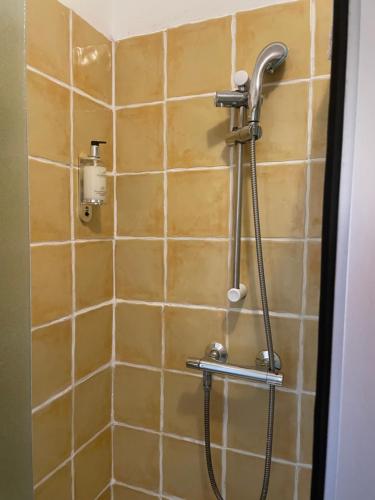 a shower with a hose in a tiled bathroom at Aparthotel Blackpool in Blackpool