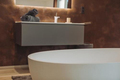 a bathroom with a white sink and a mirror at Villa au Petit Bonheur avec clim - Hameau au calme - piscine chauffée - pétanque in Moncrabeau