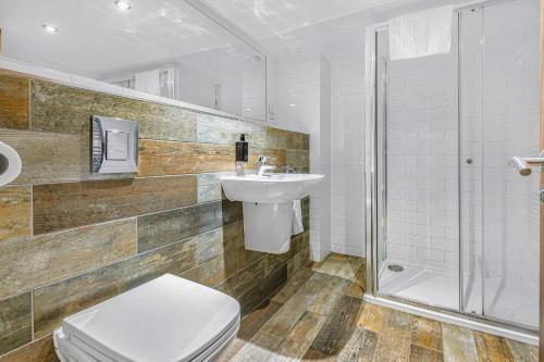 a bathroom with a toilet and a sink and a shower at The Ainscow Hotel in Manchester