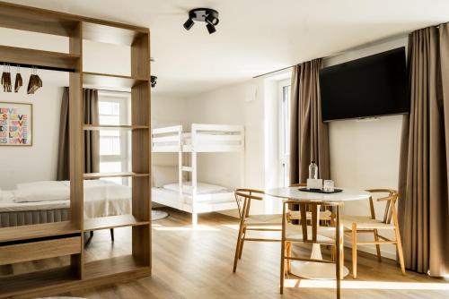 a bedroom with bunk beds and a table and chairs at Sedan Apartments Günzburg - Nahe Legoland - Familienurlaub in Günzburg