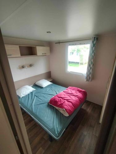 - un petit lit dans une petite chambre avec fenêtre dans l'établissement Mobil-Home Location de Vacances, à Talmont-Saint-Hilaire