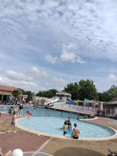 un groupe de personnes dans une piscine dans l'établissement Mobil-Home Location de Vacances, à Talmont-Saint-Hilaire
