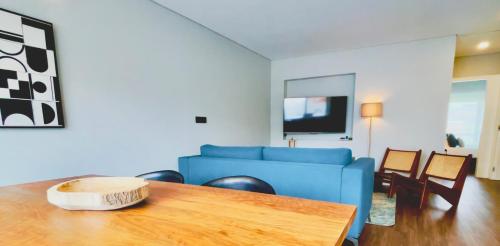 a living room with a blue couch and a table at NearTheSEA by YoursPorto in Matosinhos