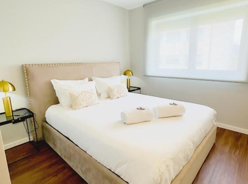 a bedroom with a large white bed with two pillows at NearTheSEA by YoursPorto in Matosinhos