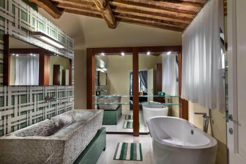 a bathroom with a large tub and a sink at La Pieve di San Giovanni Luxury Retreat & Spa in Lustignano