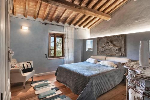 a bedroom with a bed and a chair at La Pieve di San Giovanni Luxury Retreat & Spa in Lustignano