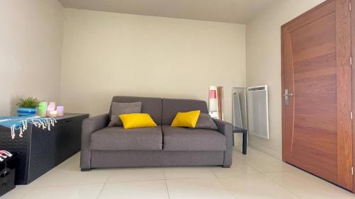 - un salon avec un canapé et 2 oreillers jaunes dans l'établissement Studio Suquet Near Palais Et Plages, à Cannes