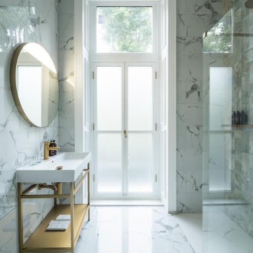 a bathroom with a sink and a mirror at Ellen Kensington in London
