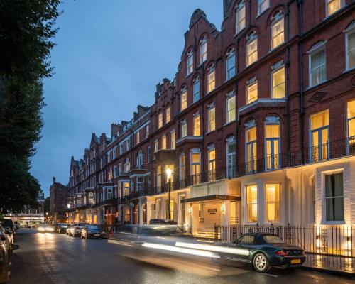 a car driving down a city street at night at Ellen Kensington in London