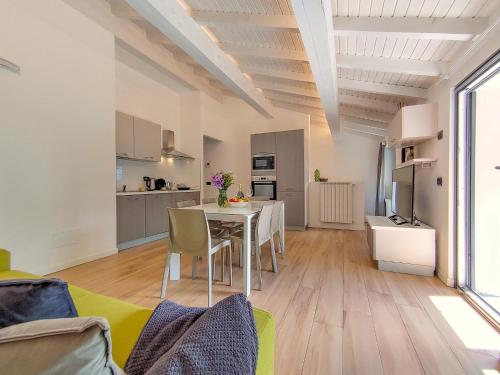 a living room with a table and a kitchen at Dascio Salute Ferienwohnung mit Panorama Balkon am See in Dascio