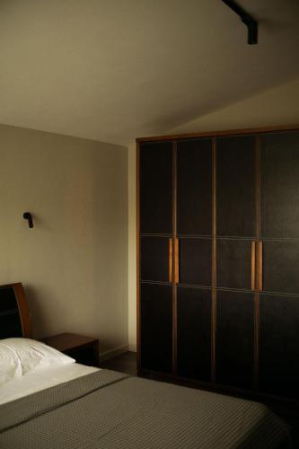 a bedroom with a bed and a large closet at Secret Stone Villa in Tirana