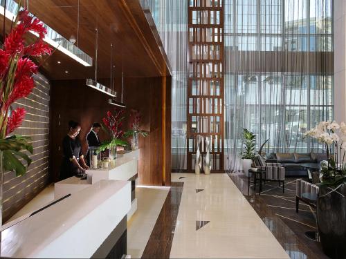 two people standing in the lobby of a building at Ramada by Wyndham Dubai Barsha Heights in Dubai