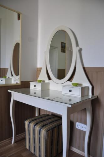 a white dressing table with a large mirror on it at Gloriett Panzió in Fertőboz