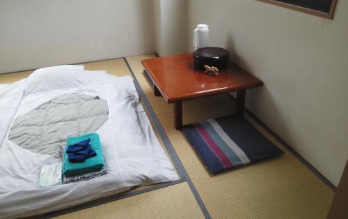 白馬村にある白馬グラードイン　えびすやのテーブルとベッドが備わる部屋のコーナー
