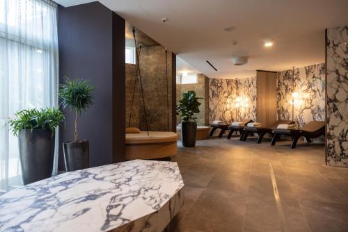 Una habitación de hotel con una cama, mesas y plantas. en Palace Hotel Città, en Arco