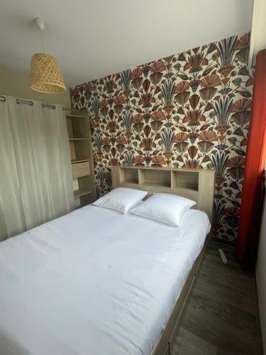 - une chambre avec un lit blanc et un mur dans l'établissement Charming and Cosy Apartment near Paris, à Houilles