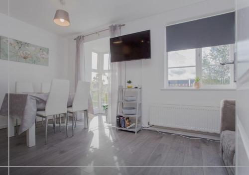 a white living room with a table and chairs at Modern 5BR Home Near City Attractions - Peterborough in Peterborough