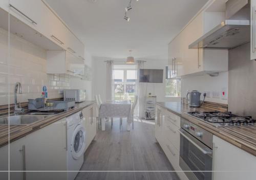 a large white kitchen with a sink and a dishwasher at Modern 5BR Home Near City Attractions - Peterborough in Peterborough