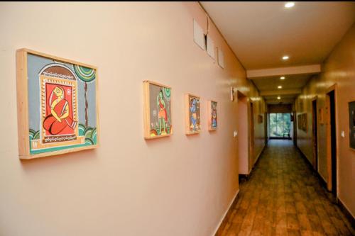 a hallway with paintings on the walls of a building at Dip Holidays in Shānti Niketan