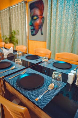 a table with black plates on a blue at Dip Holidays in Shānti Niketan