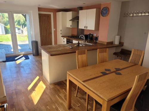 a kitchen and dining room with a wooden table at Little Willows in Handcross