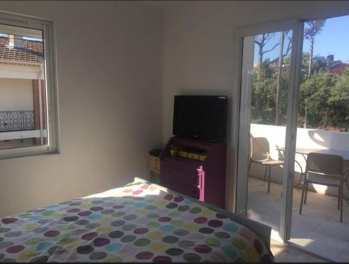 une chambre avec un lit et une télévision et un balcon dans l'établissement Appart 3 chambres - Mer à pied, à Saint-Aygulf