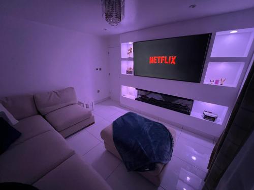 a living room with a white couch and a tv at 3 Bedroom House in Northampton