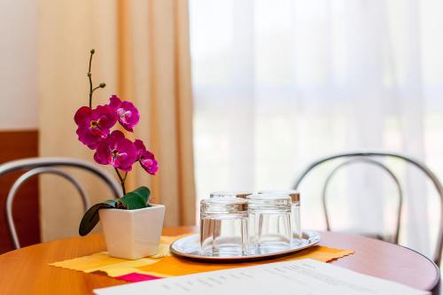 a wooden table with a vase with purple flowers on it at Penzión Centrum in Oravský Biely Potok