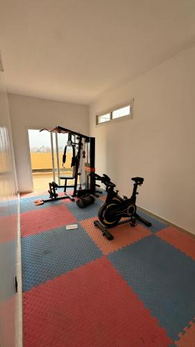 a room with a gym with two exercise bikes at Appartement moderne et lumineux in Derklé