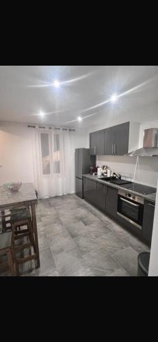 une grande cuisine avec une table et une cuisinière dans l'établissement Joli maison refait à neuf #1, à Vierzon