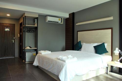 a bedroom with a large white bed in a room at Bluemoon in Cha Am