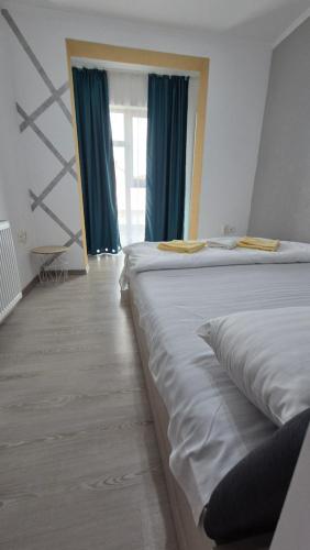 1 dormitorio con 2 camas y cortinas azules en Pomiculturii Residence 9, en Timisoara
