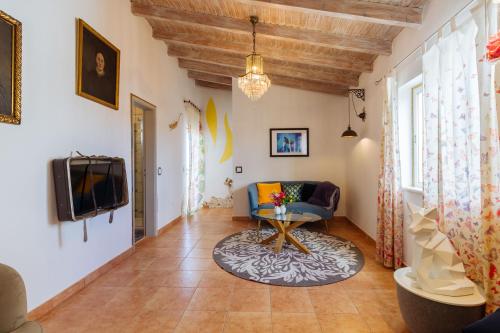 a living room with a blue couch and a tv at Casa tempo e amor in Vila do Bispo
