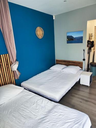 - 2 lits dans une chambre avec un mur bleu dans l'établissement Tra mare e lago, à Montescot