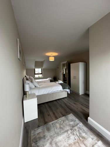 a bedroom with a large white bed and wooden floors at 54 Stracomer Hill Bundoran in Single Street
